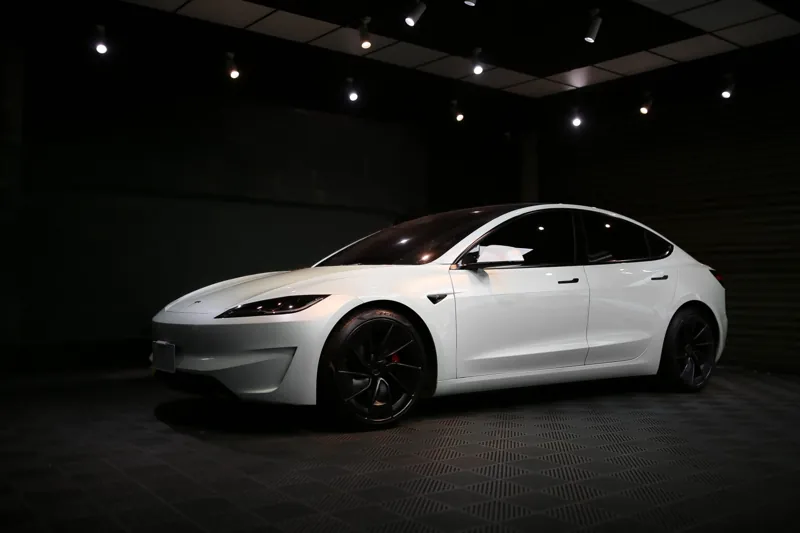 貼好亮面犀牛皮的白色 Tesla Model 3 前斜角,停在御守車匠攝影棚中