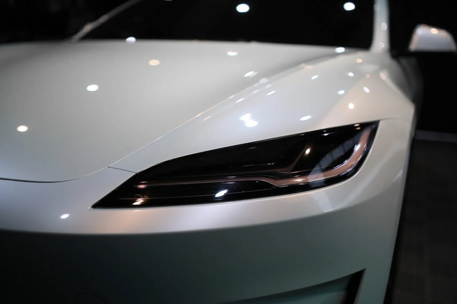 Tesla Model 3 頭燈與引擎蓋的亮面透明犀牛皮特寫，原廠白漆光澤保留，御守車匠施工