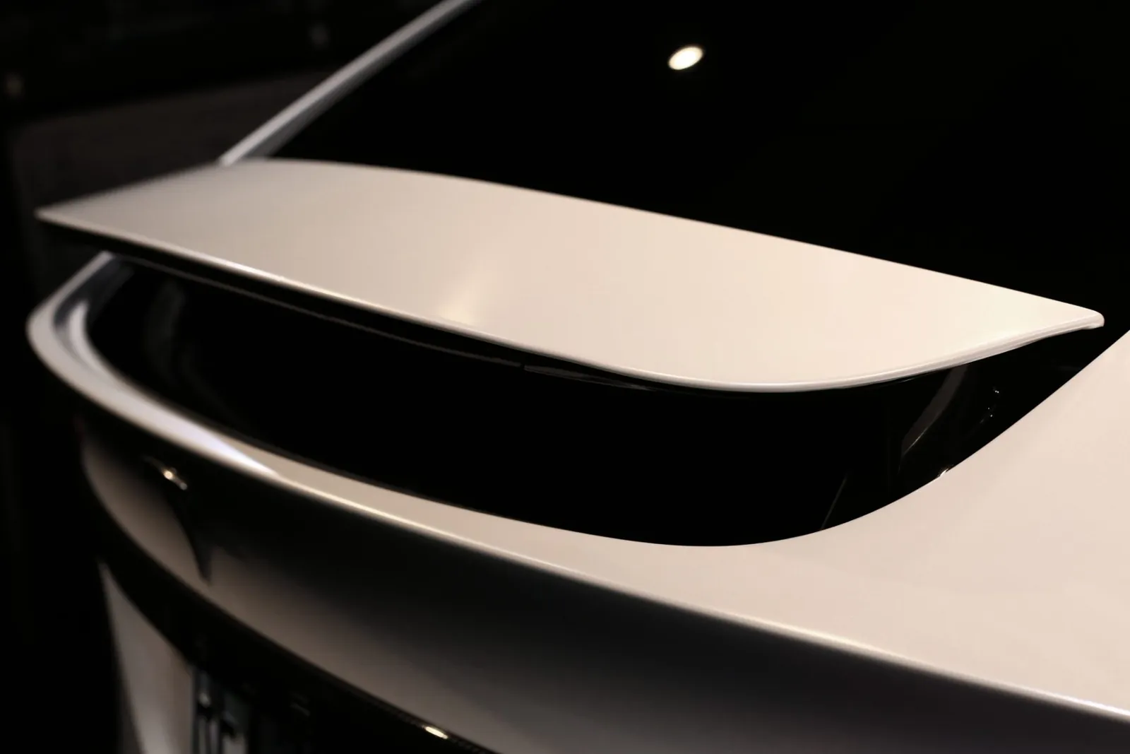 Tesla Model X 尾翼的消光珍珠白改色膜特寫，霧面質感均勻、邊緣貼合