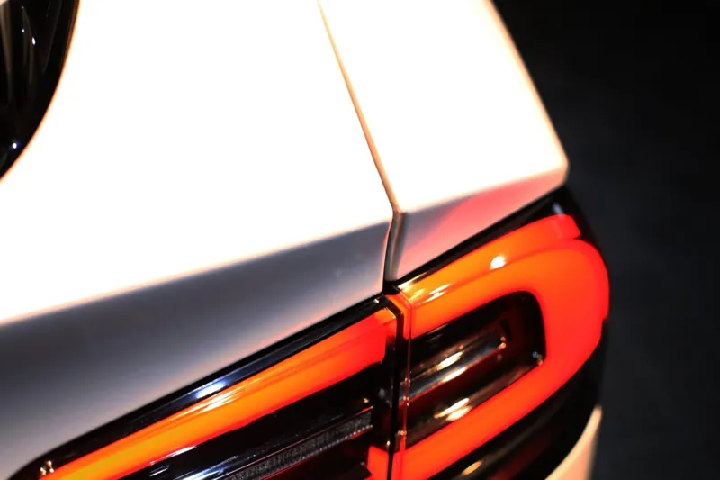 Tesla Model X 尾燈旁的消光珍珠白改色膜接縫特寫，收邊線貼齊原廠分件線