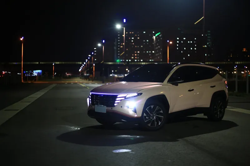 全車改色亮面粉的 Hyundai Tucson 夜晚停在台中河堤道路上,大燈亮著
