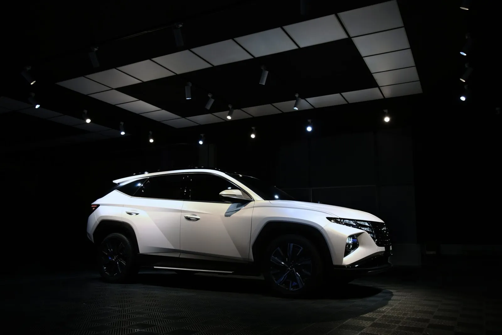 御守車匠攝影棚的頂燈下，一台全車改色消光珍珠白的 Hyundai Tucson L 斜前方停著，霧面膜色均勻